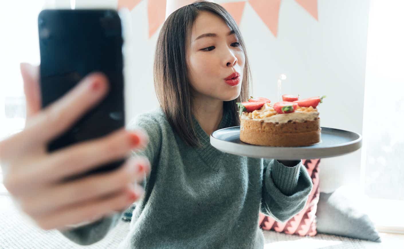 Young Woman Having A Virtual Birthday Party On Video Call With Friends Using Smart Phone