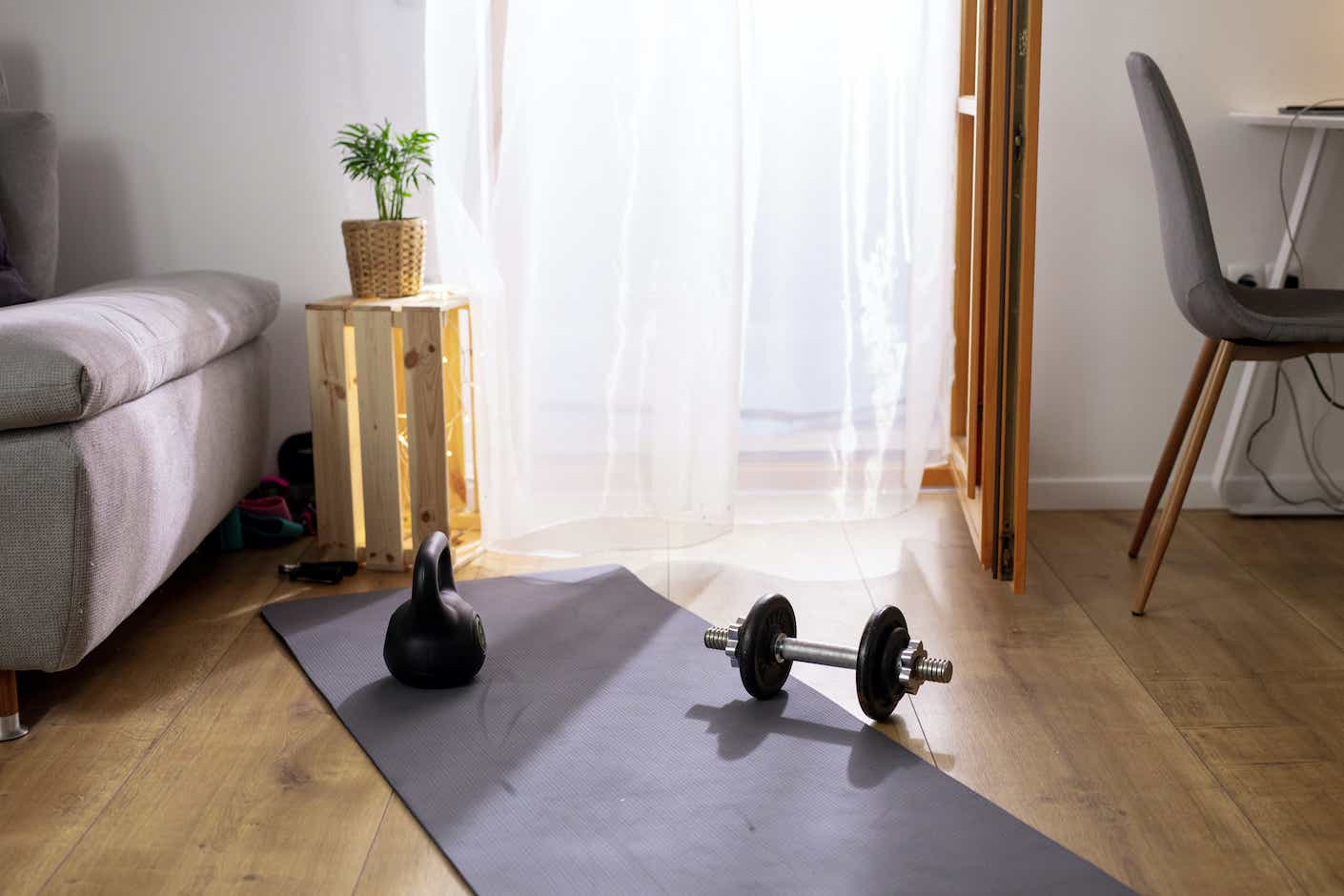 Exercise equipment on yoga mat in living room