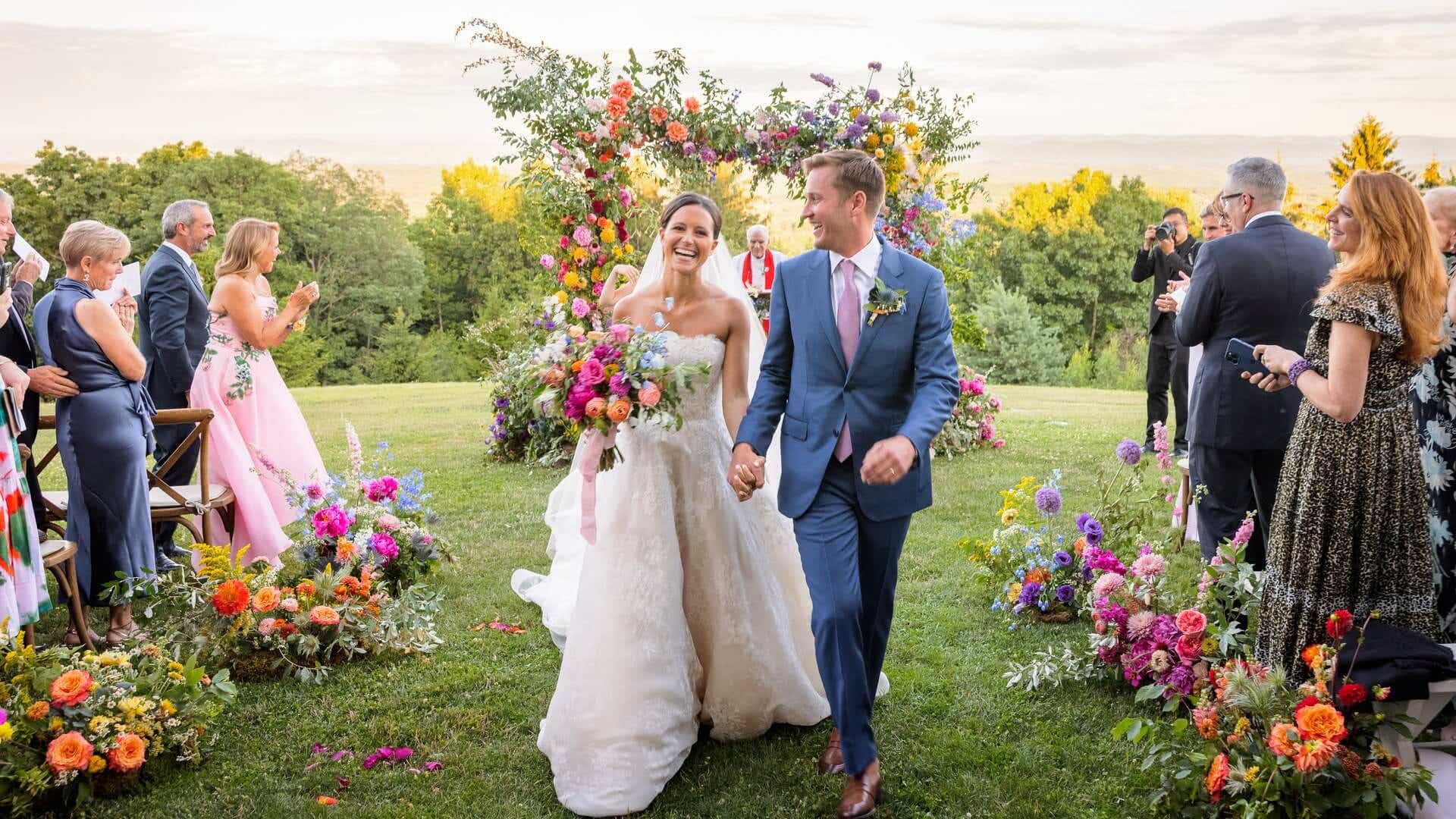 ellie monohan and her husband walking down the aisle at their wedding