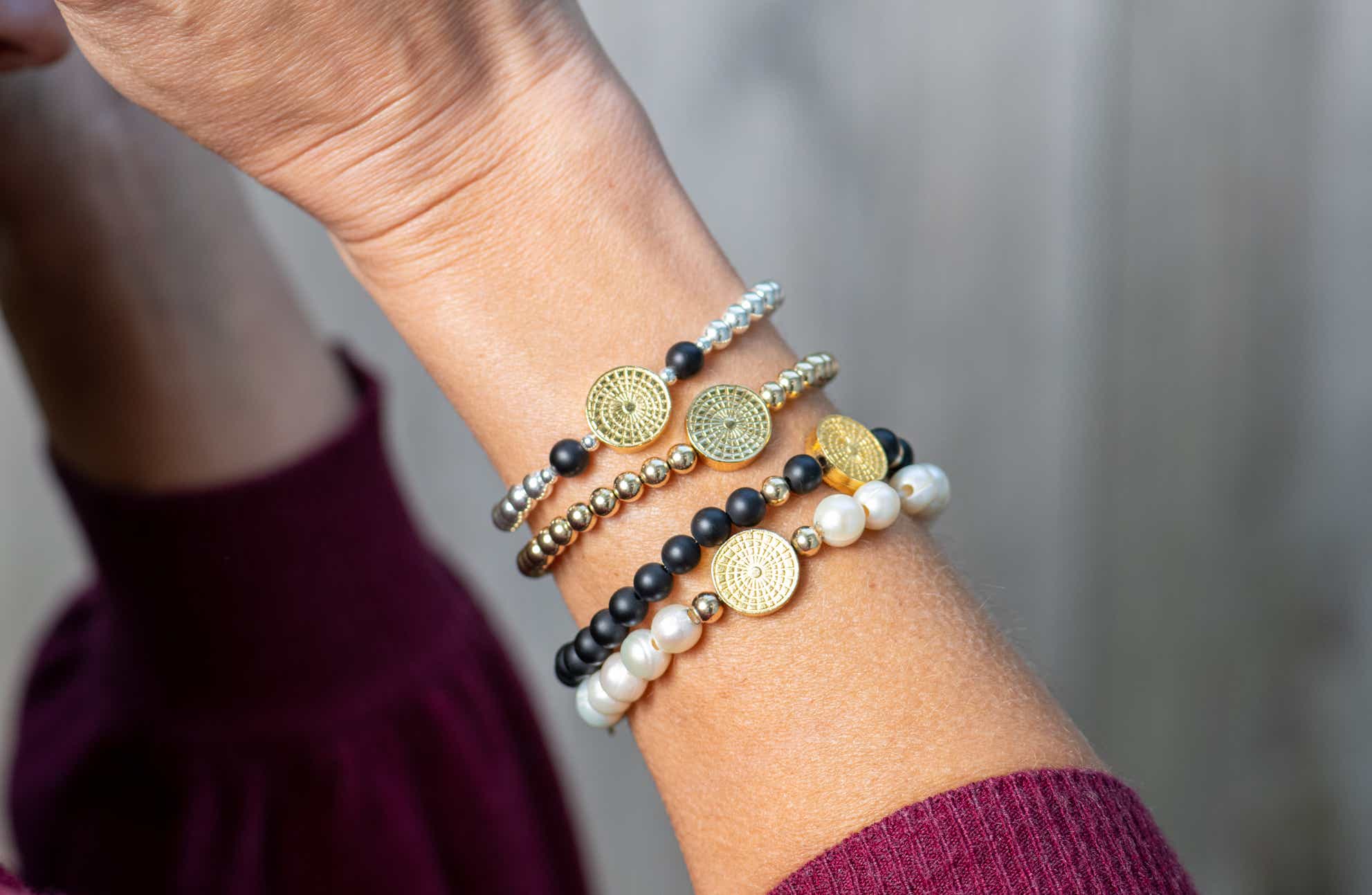 Wrist with various ElyseRyan bracelets on it