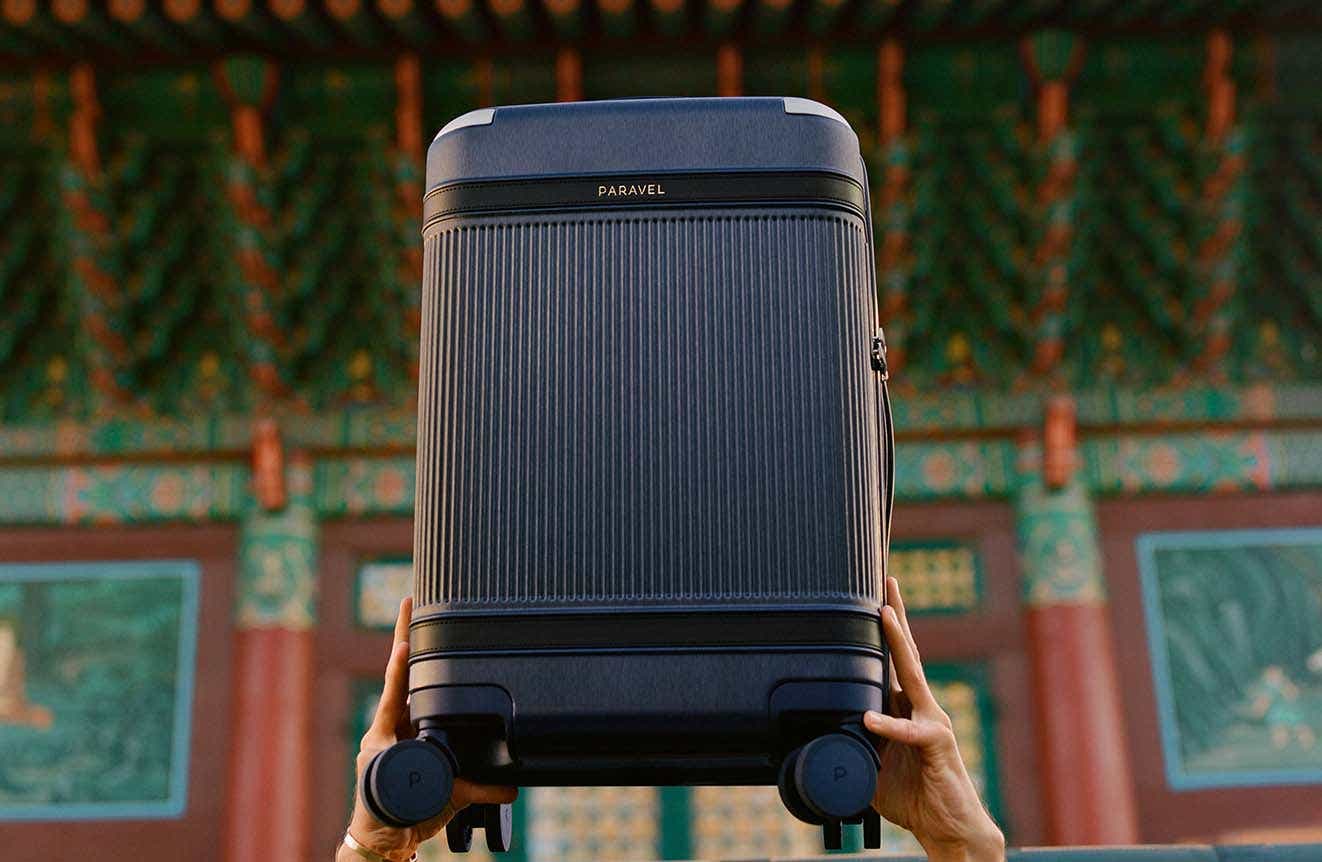 Hands holding up Paravel suitcase