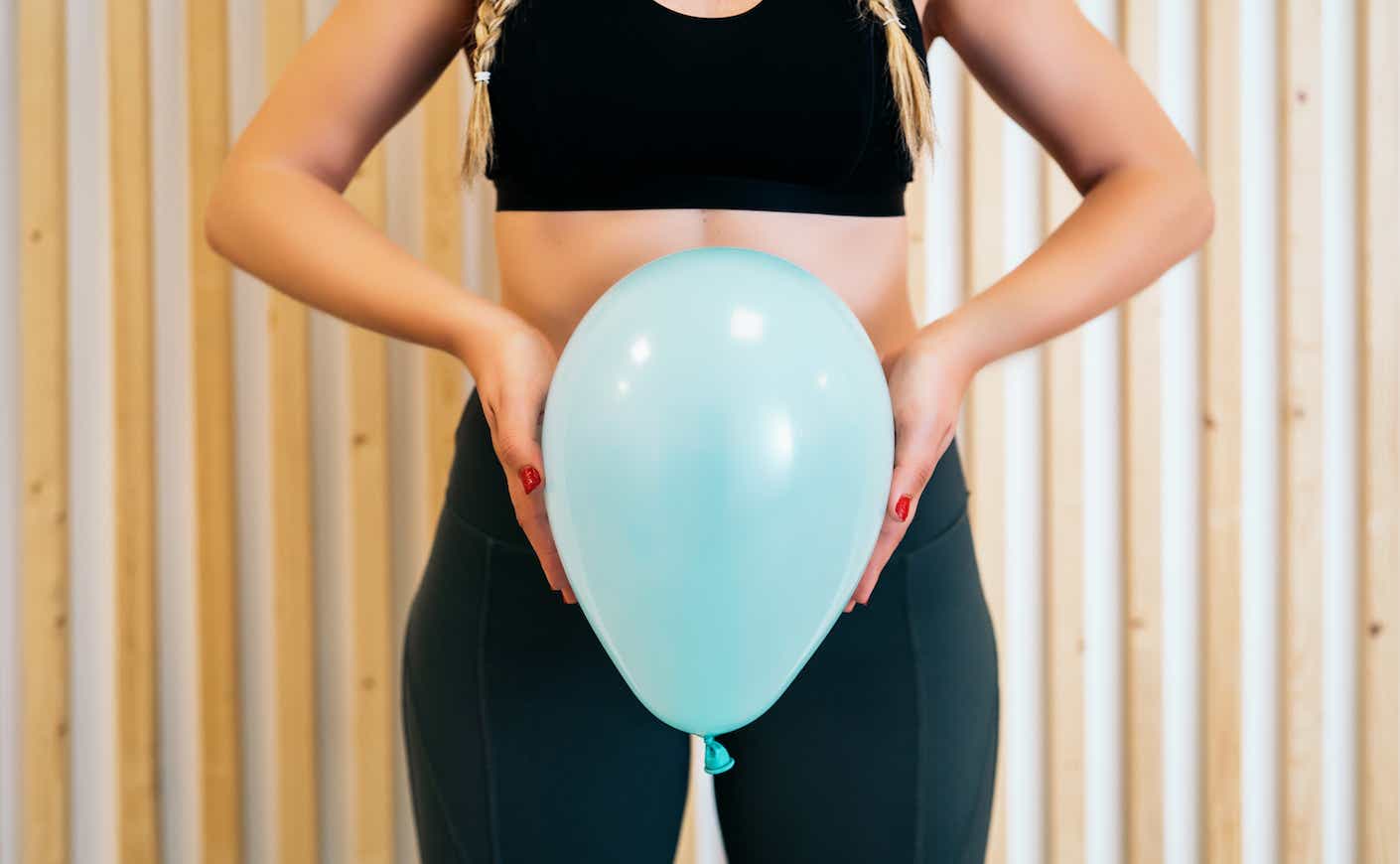 Model holding balloon to symbolize pelvic health