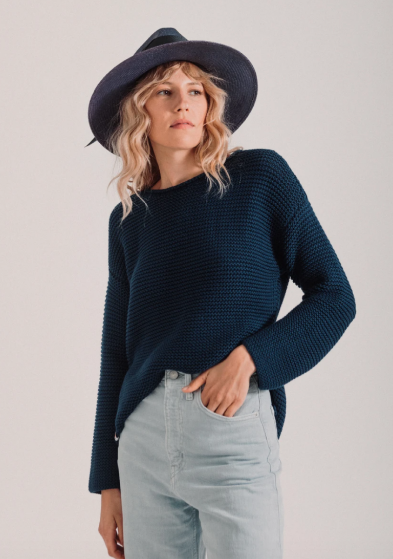 Model wearing sweater and black hat