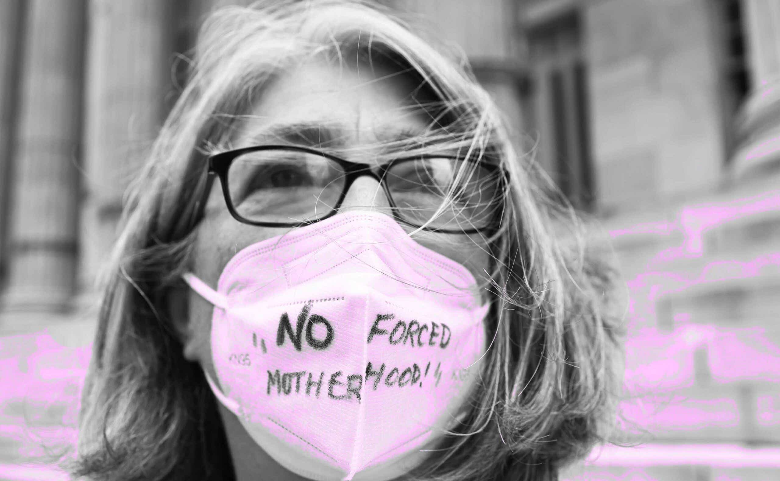 woman wearing a mask that says 'no forced motherhood'