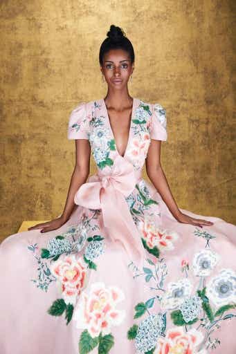 a model wearing a pink floral gown 