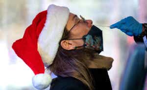 a woman wearing a santa hat is tested for Covid-19