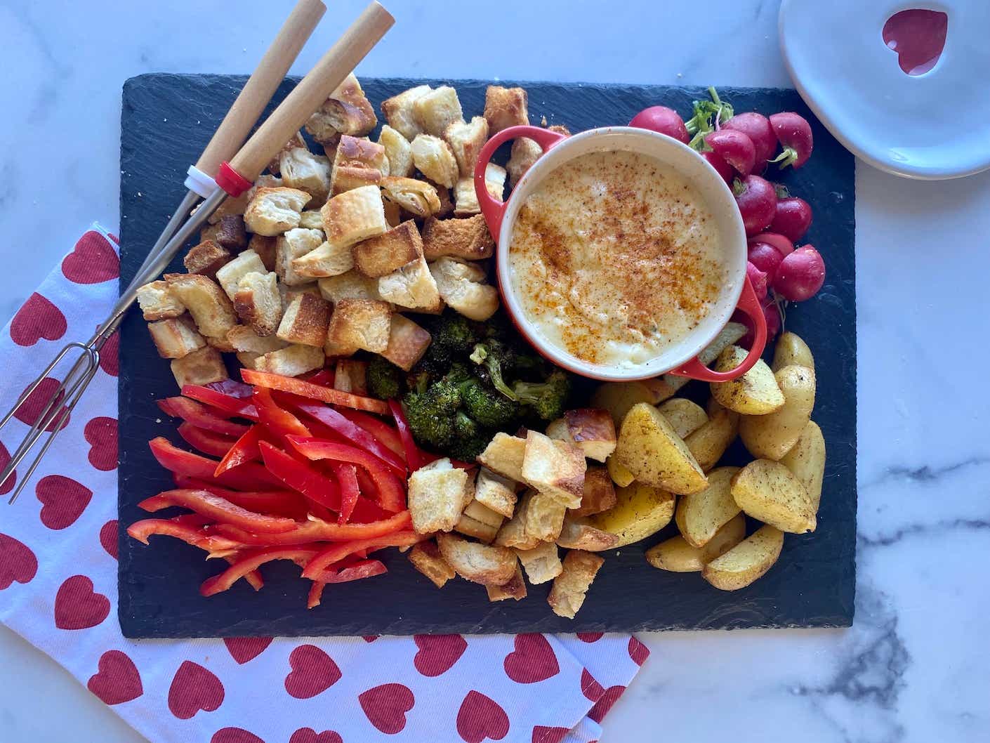 platter of cheese fondue with dipping items