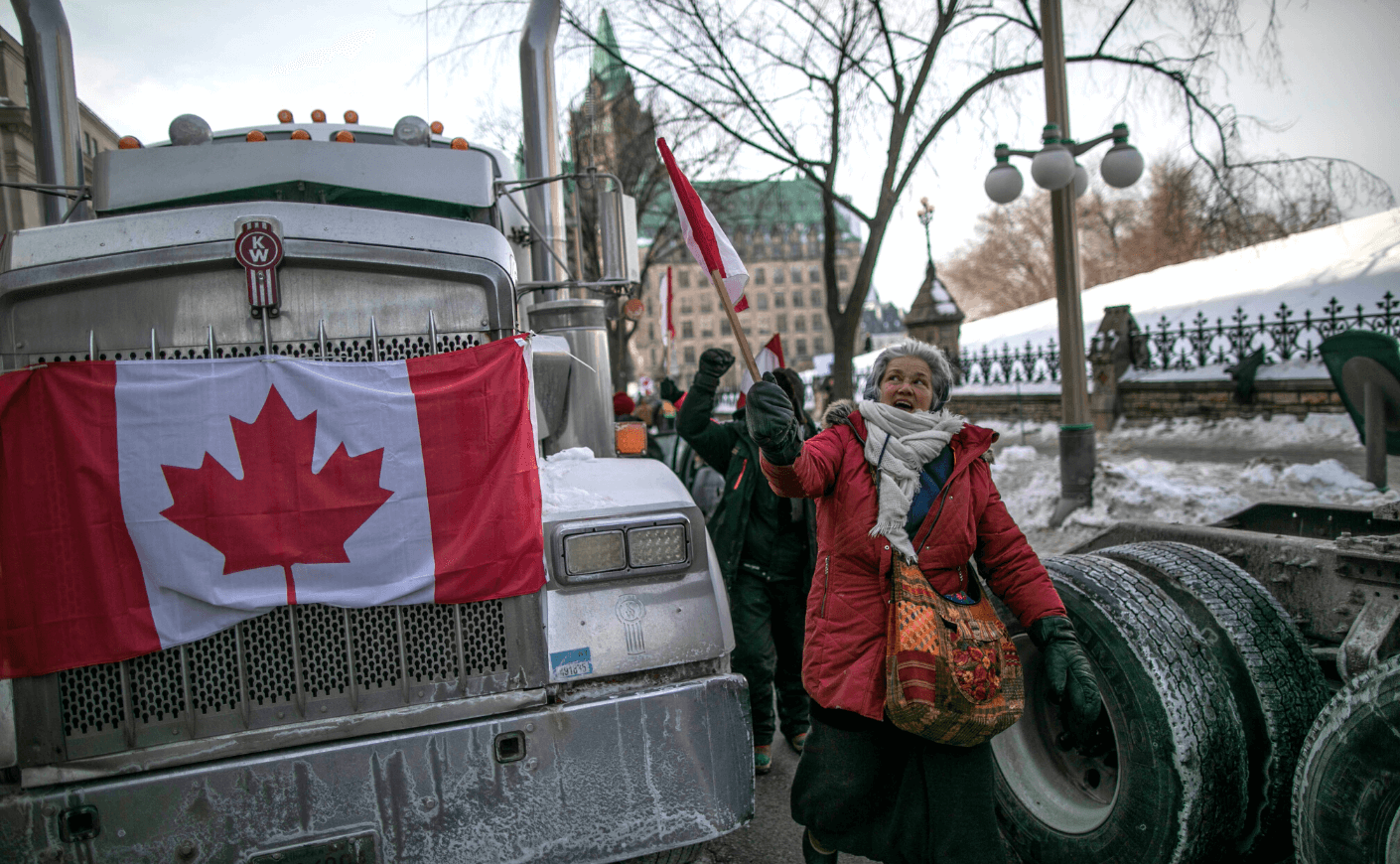 Truck with a Canadian flag and a woman holding flag