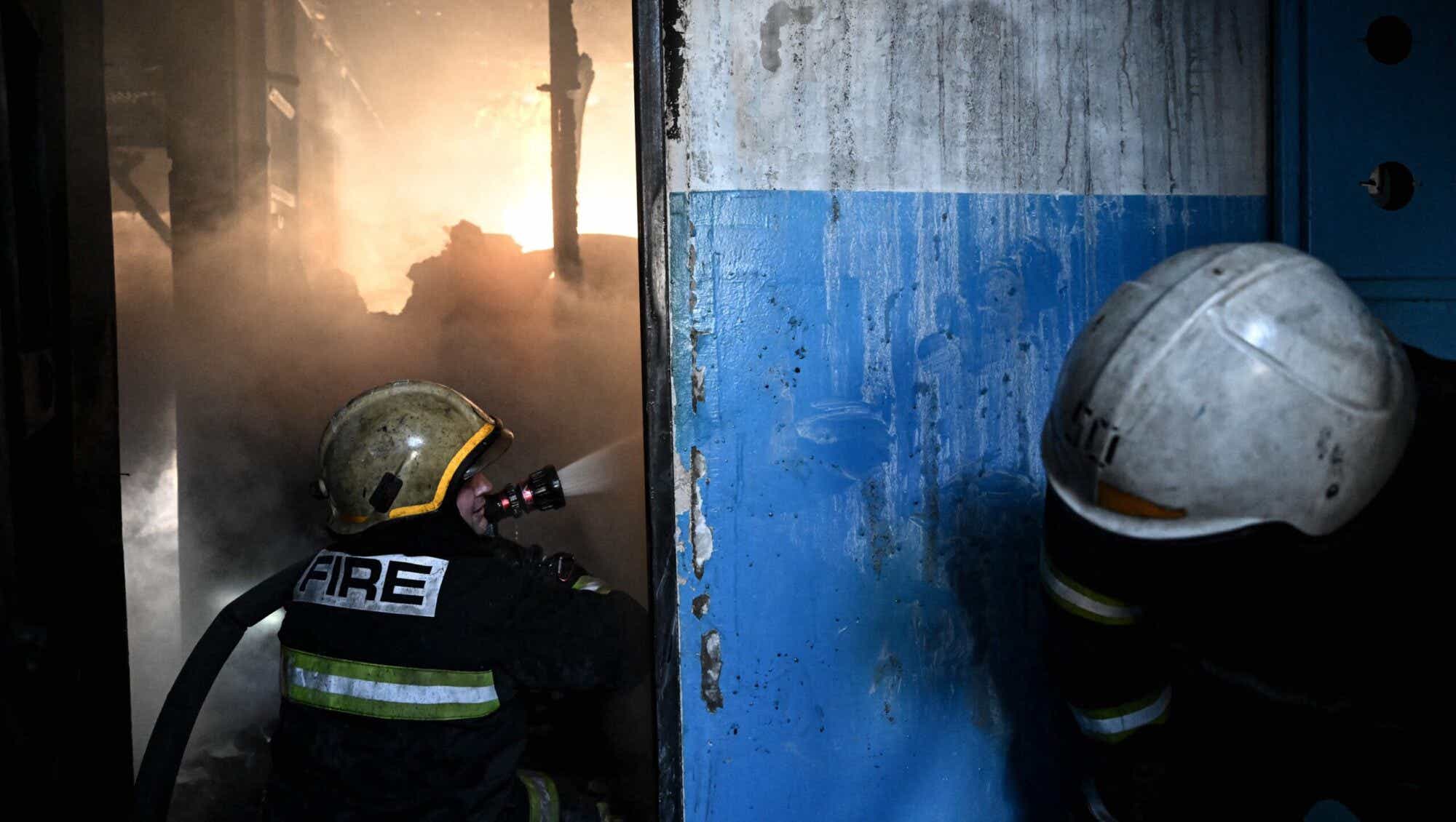 Ukrainian firefighters rush in after Russian bombs hit a building