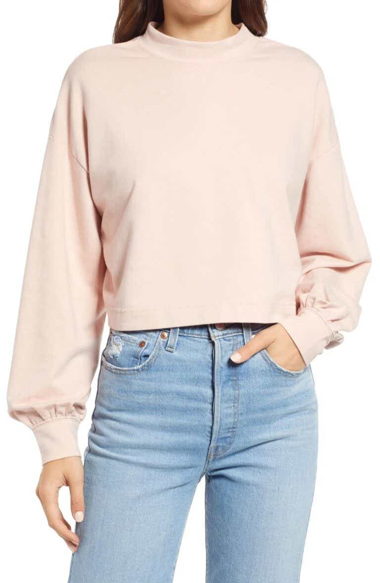 model in pink mock neck sweatshirt
