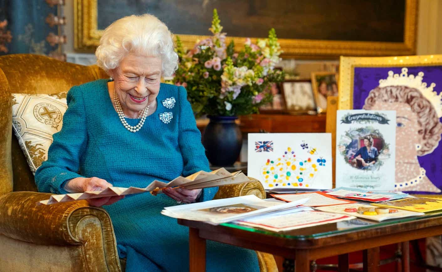 queen elizabeth sitting with her Platinum Jubilee memorabilia