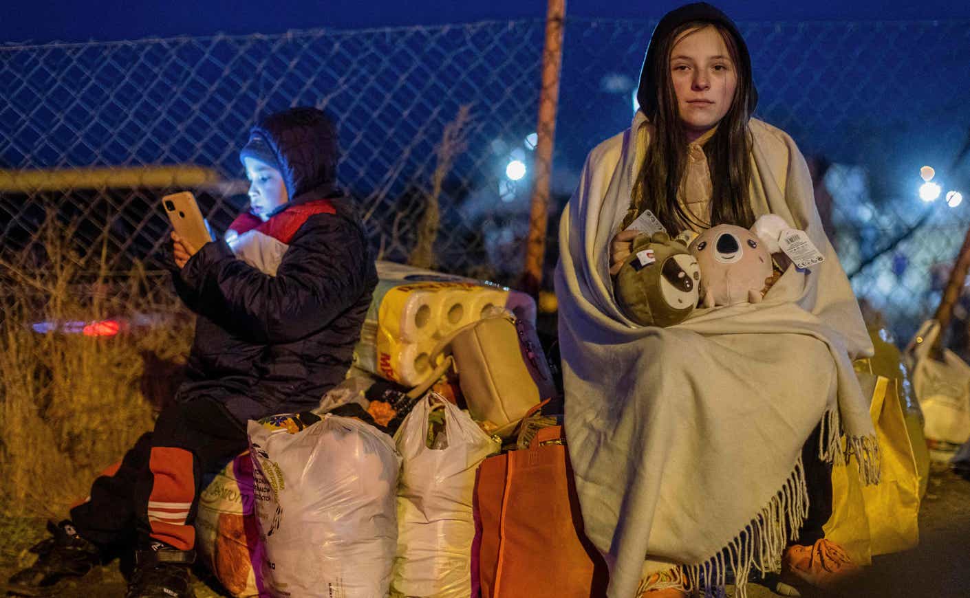 two children prepare to cross the border into Poland to flee fighting in Ukraine.