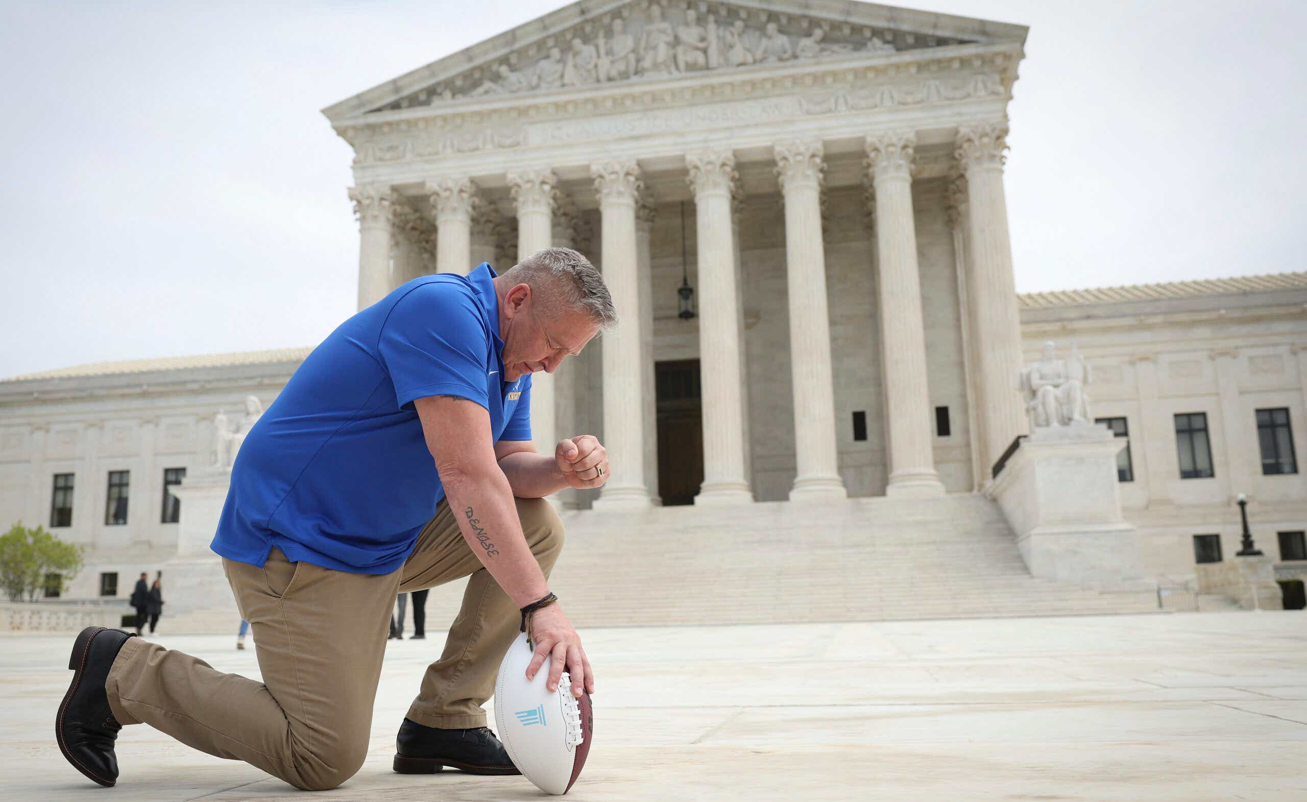 Ex football coach kneels in front of Supreme Court