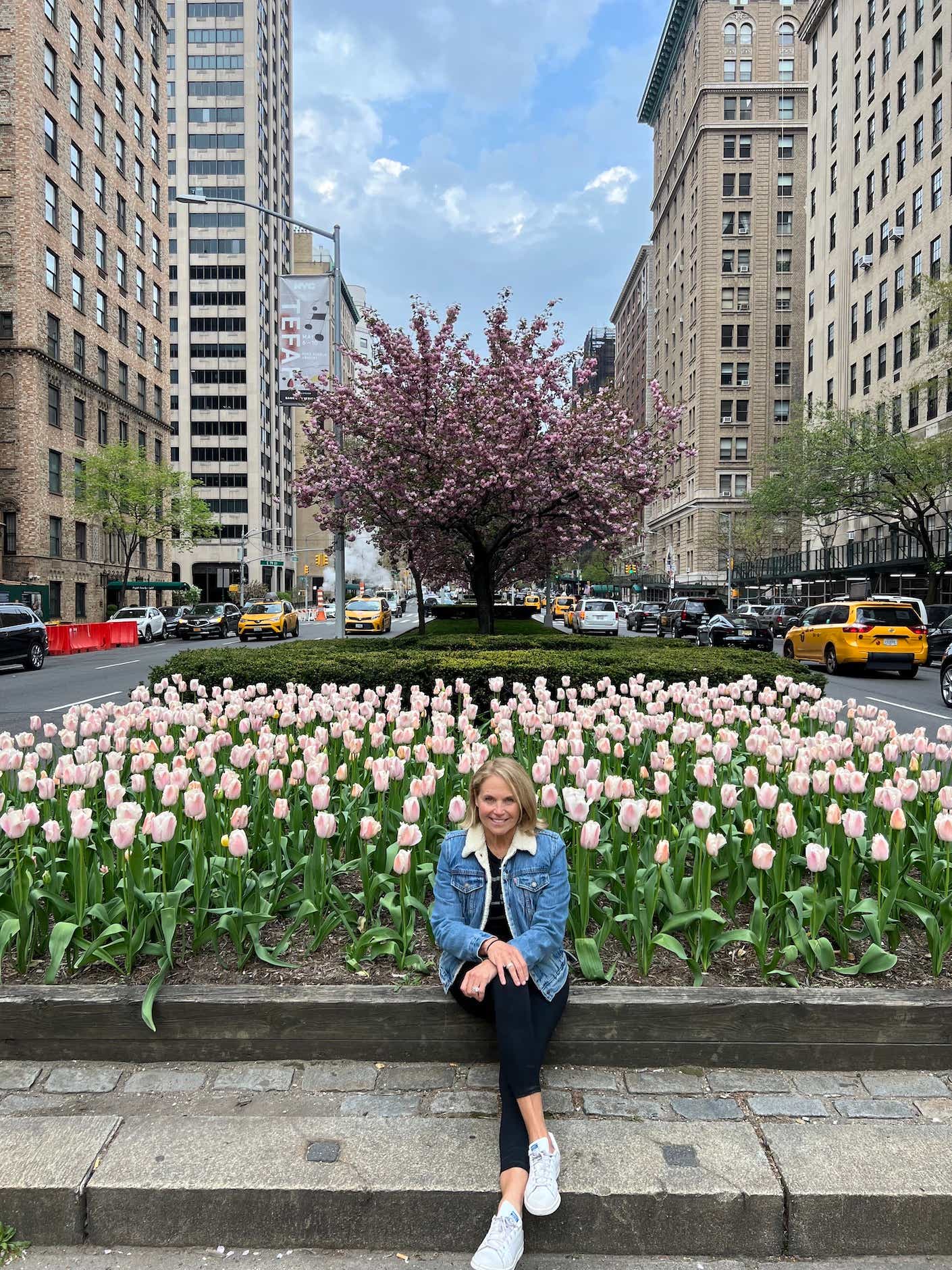 Katie Couric in front of tulips on Park Avenue 