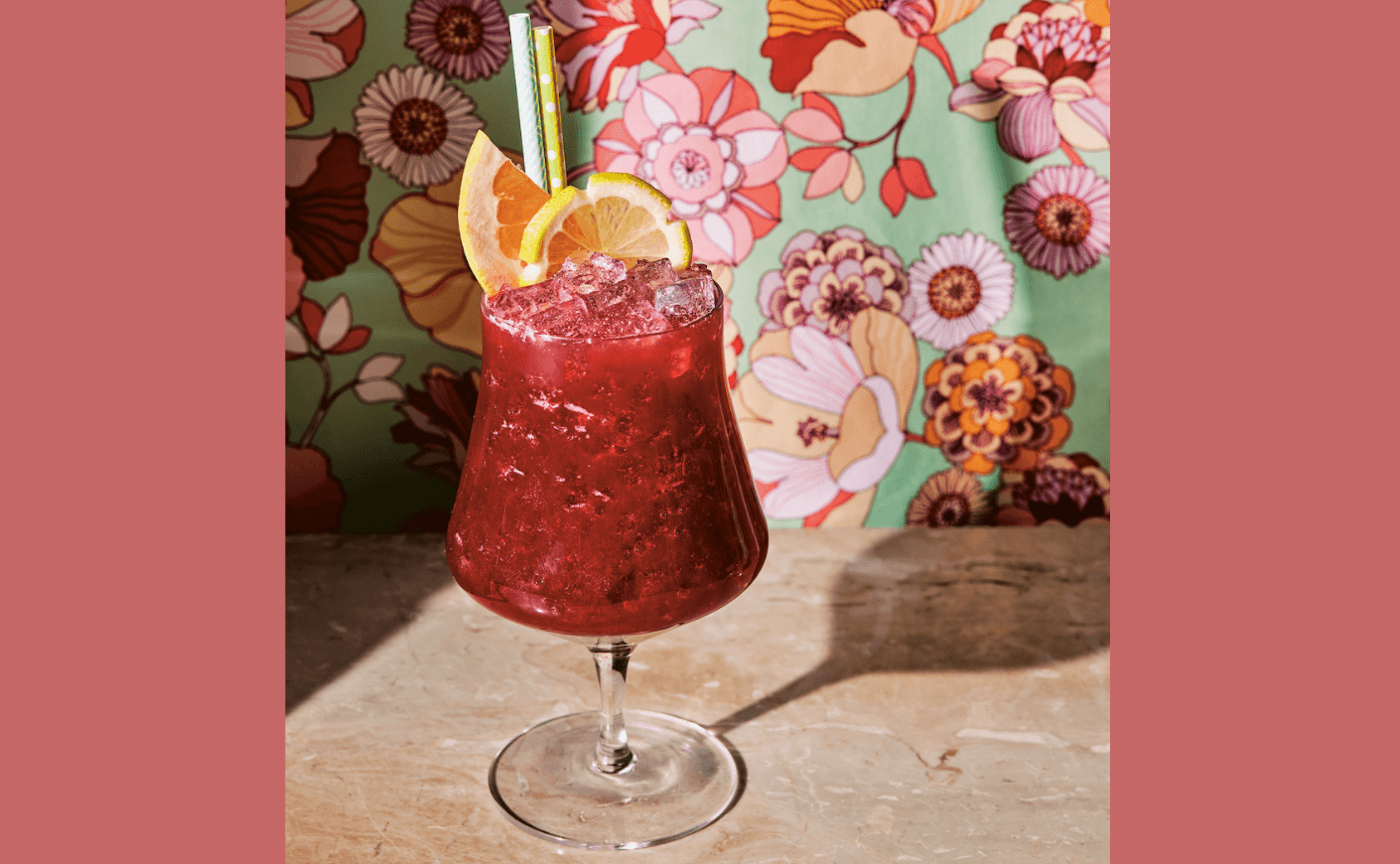 a red cocktail on a floral background