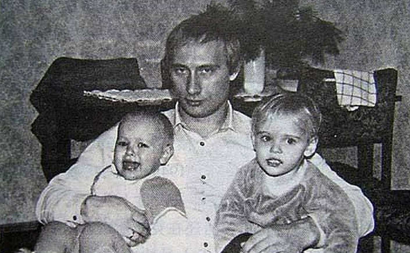 vladimir putin holding his two daughters when they were babies