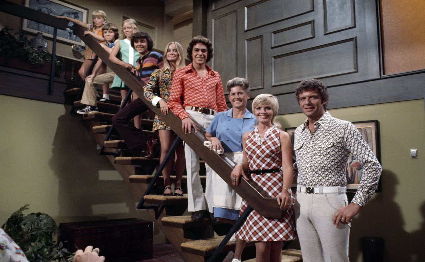 the cast of the brady bunch standing on a staircase in the family home