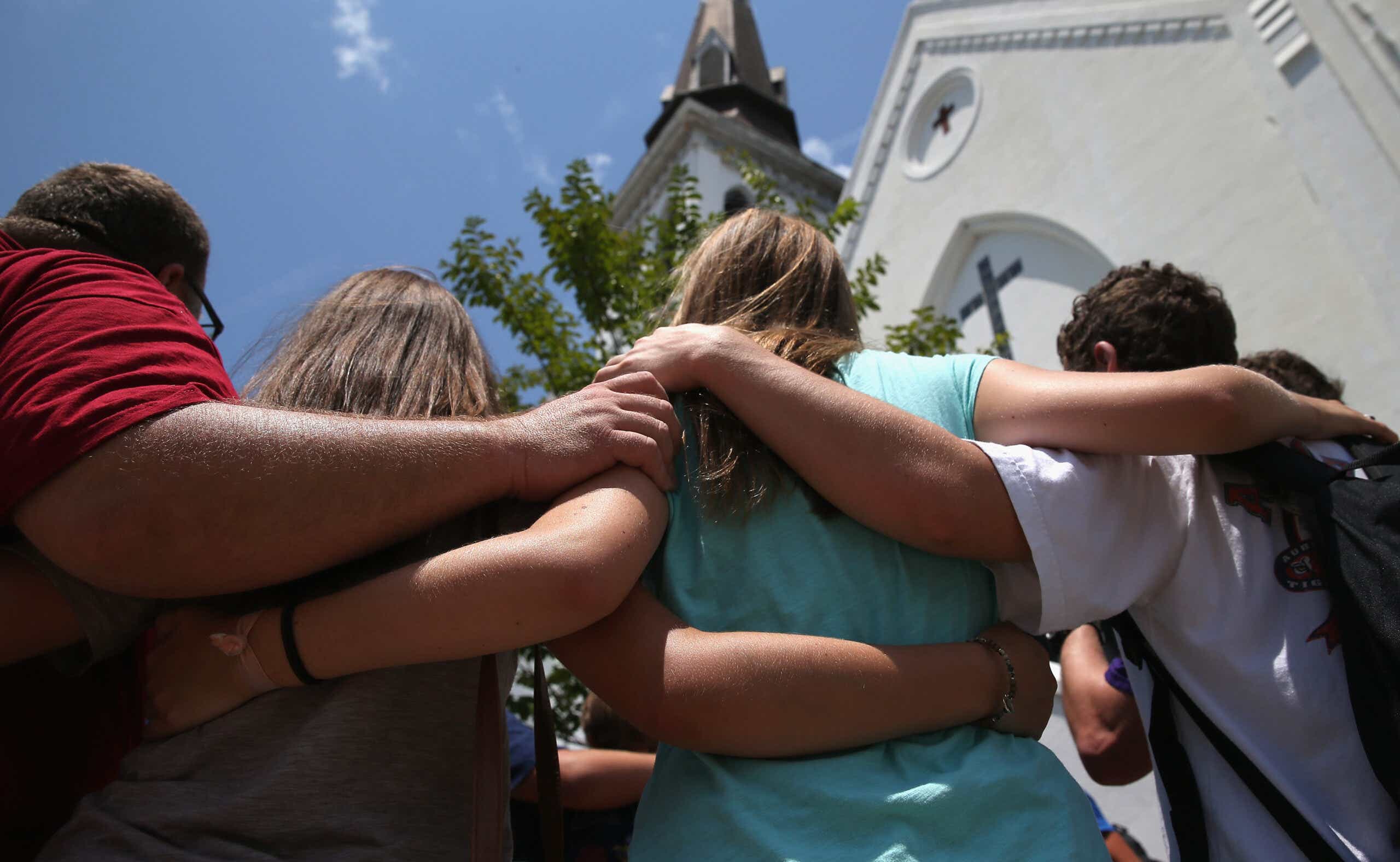 A church youth group from Douthan, Alabama prays in front of the Emanuel AME Church on the one-month anniversary of the mass shooting on July 17, 2015 in Charleston, South Carolina