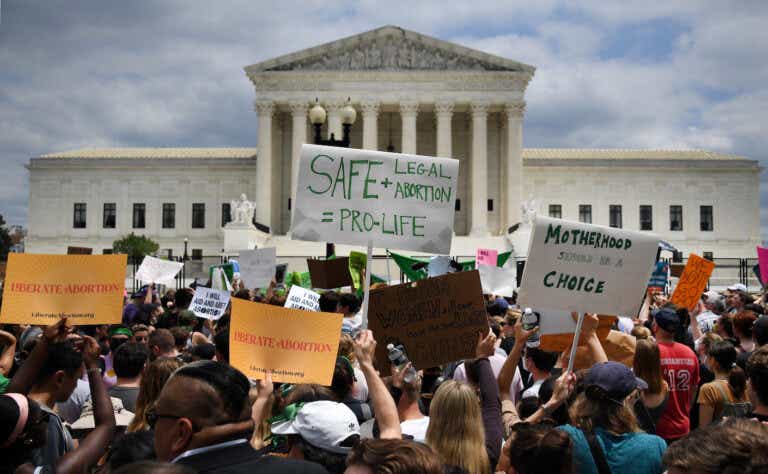 Abortion rights activists hoist their signs outside the US Supreme Court in Washington, DC, on June 24, 2022.