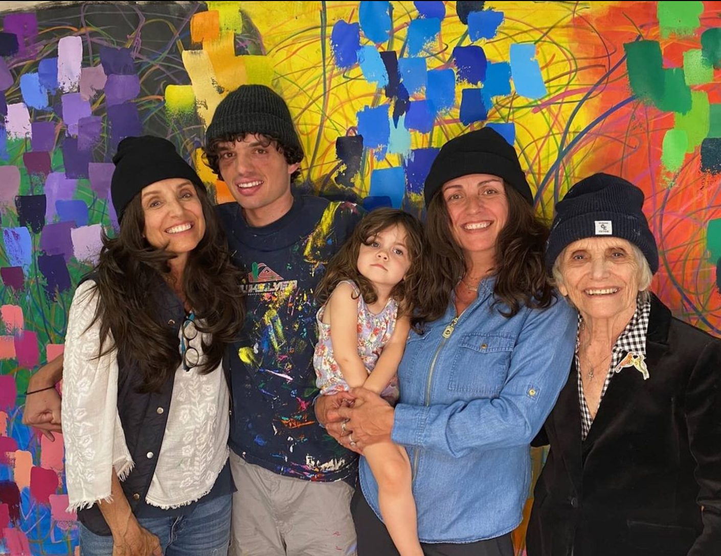 Artist Nicholas Kontaxis standing with his family in front of one of his pieces