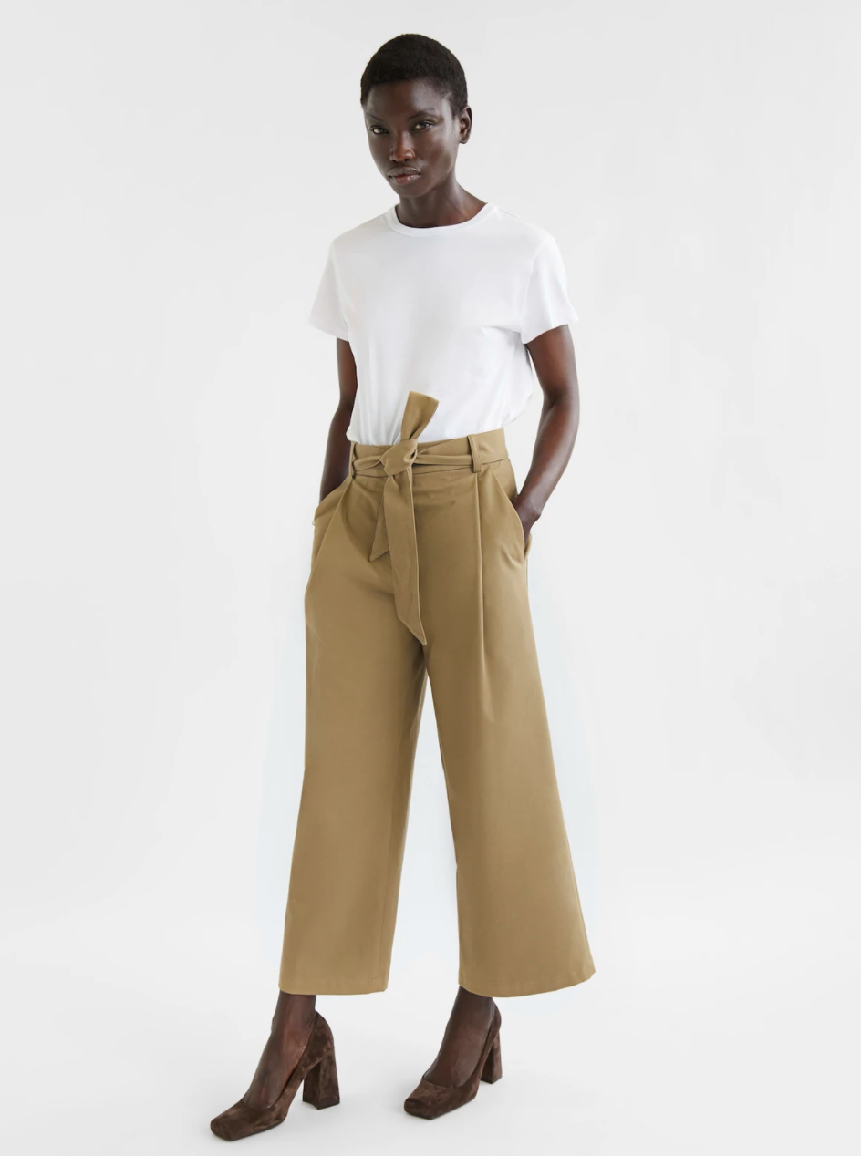 Woman wearing white tee and wide leg trousers