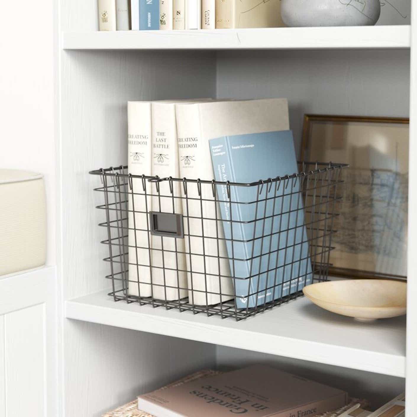 A rustic yet industrial wire storage basket holds some books.
