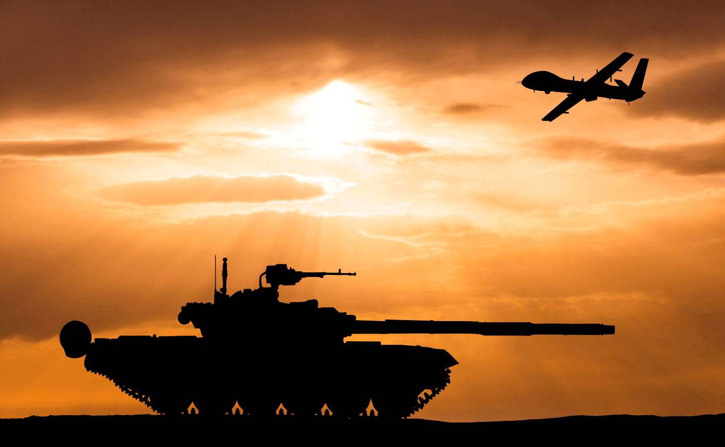 a tank and drone are backlit in the sunset