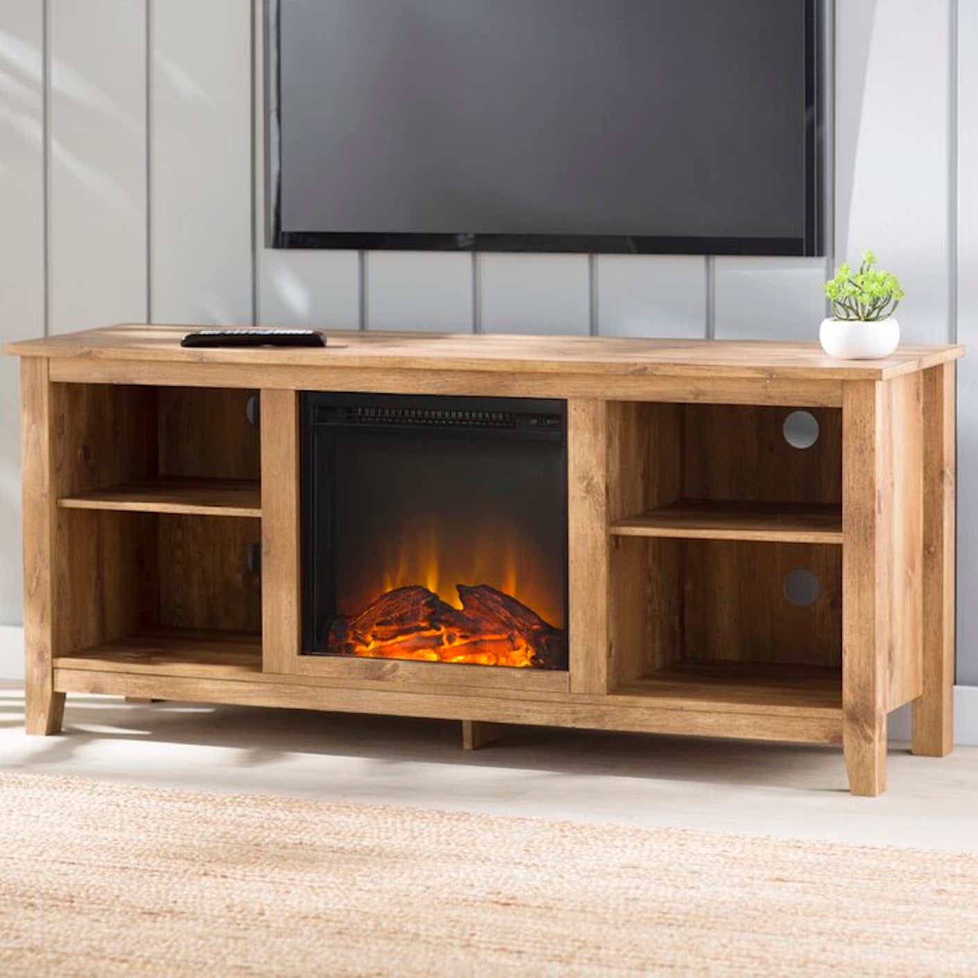 A wooden entertainment center with built-in electric fireplace sits beneath a mounted television.