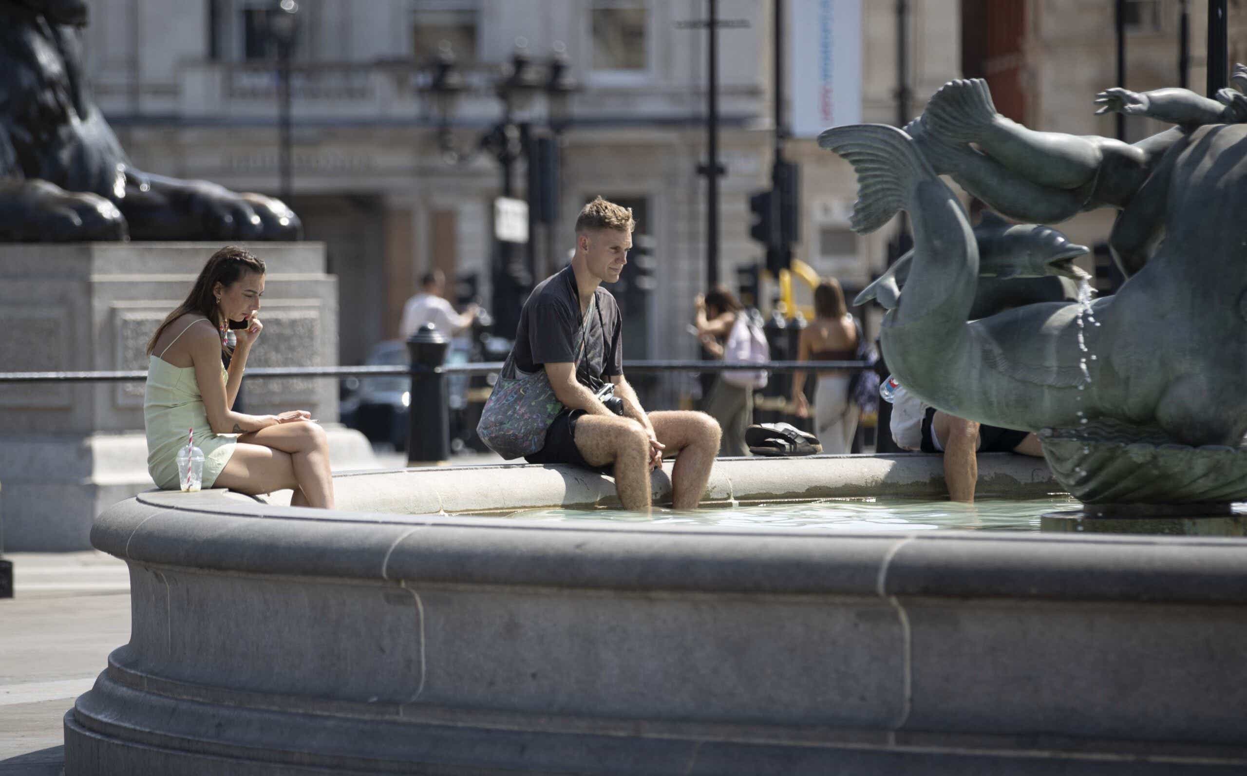 Londoners try to cool off in Trafalgar Square's fountain