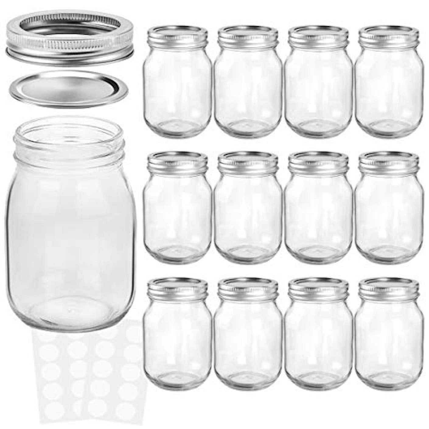 A set of clear mason jars with silver lids pictured in front of a white background.