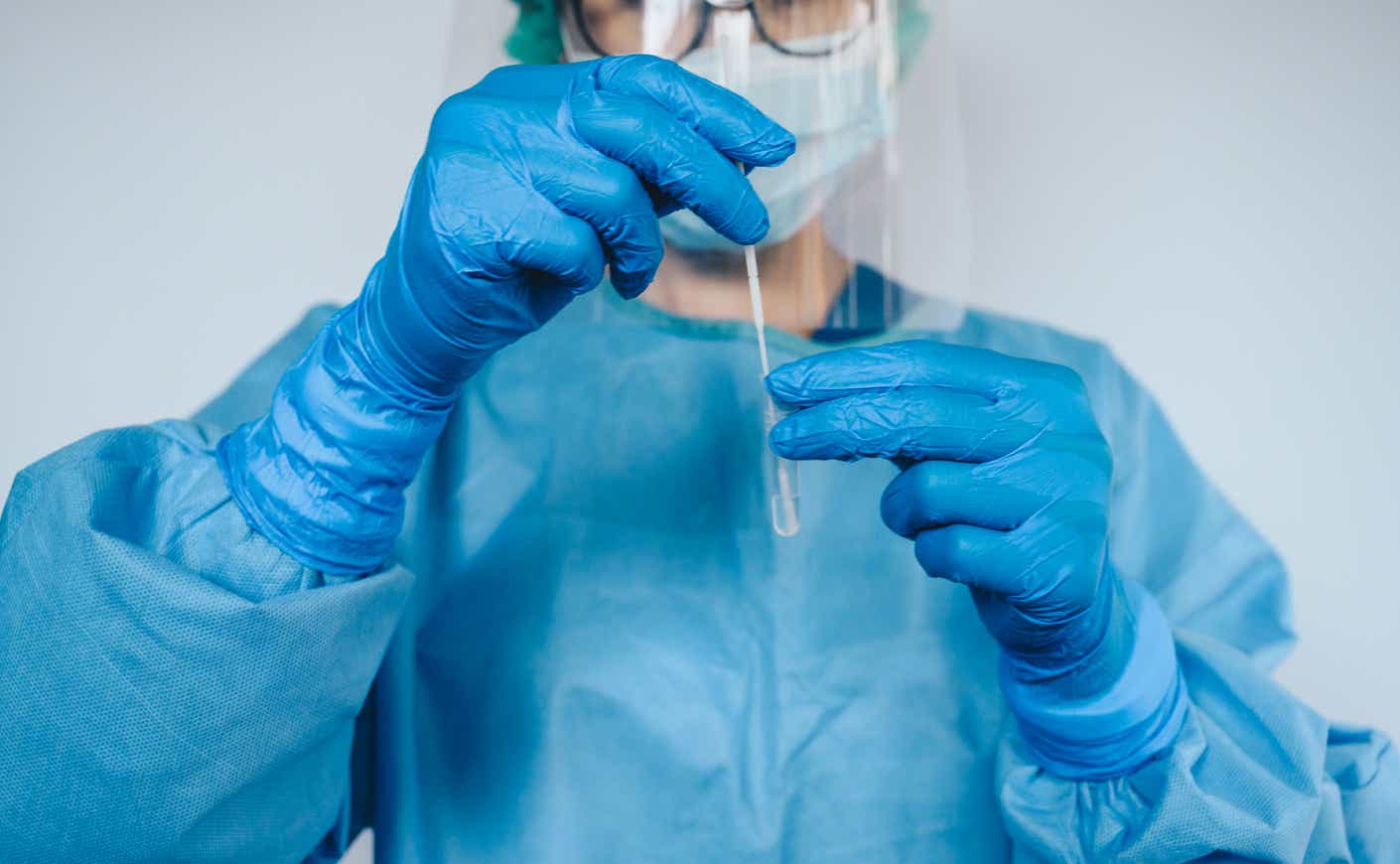 a healthcare worker places a swab in a vial