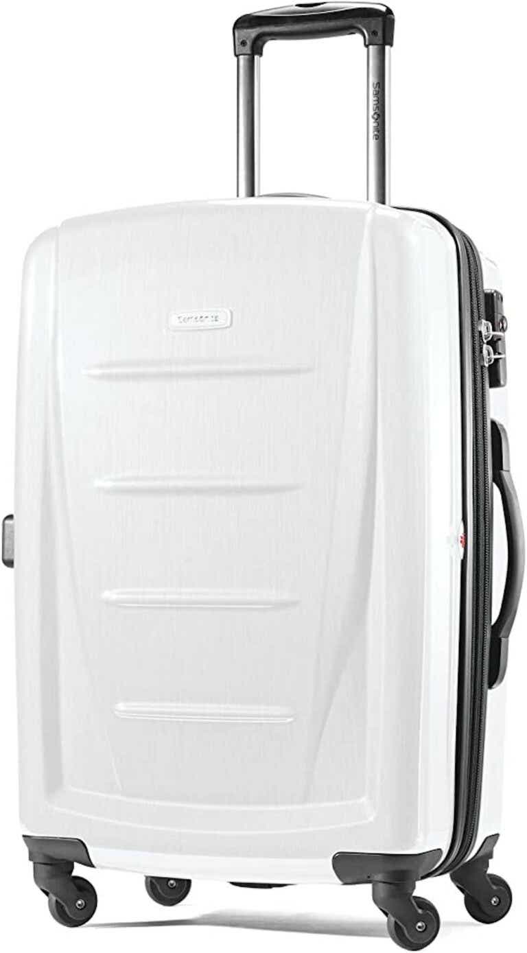 A white, hardsided suitcase with a black handle pictured in front of a white background.