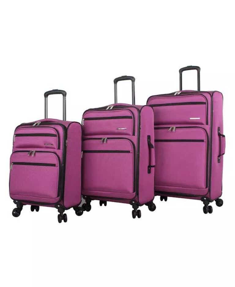 Three pink, softsided suitcases of different sizes stand in a line.