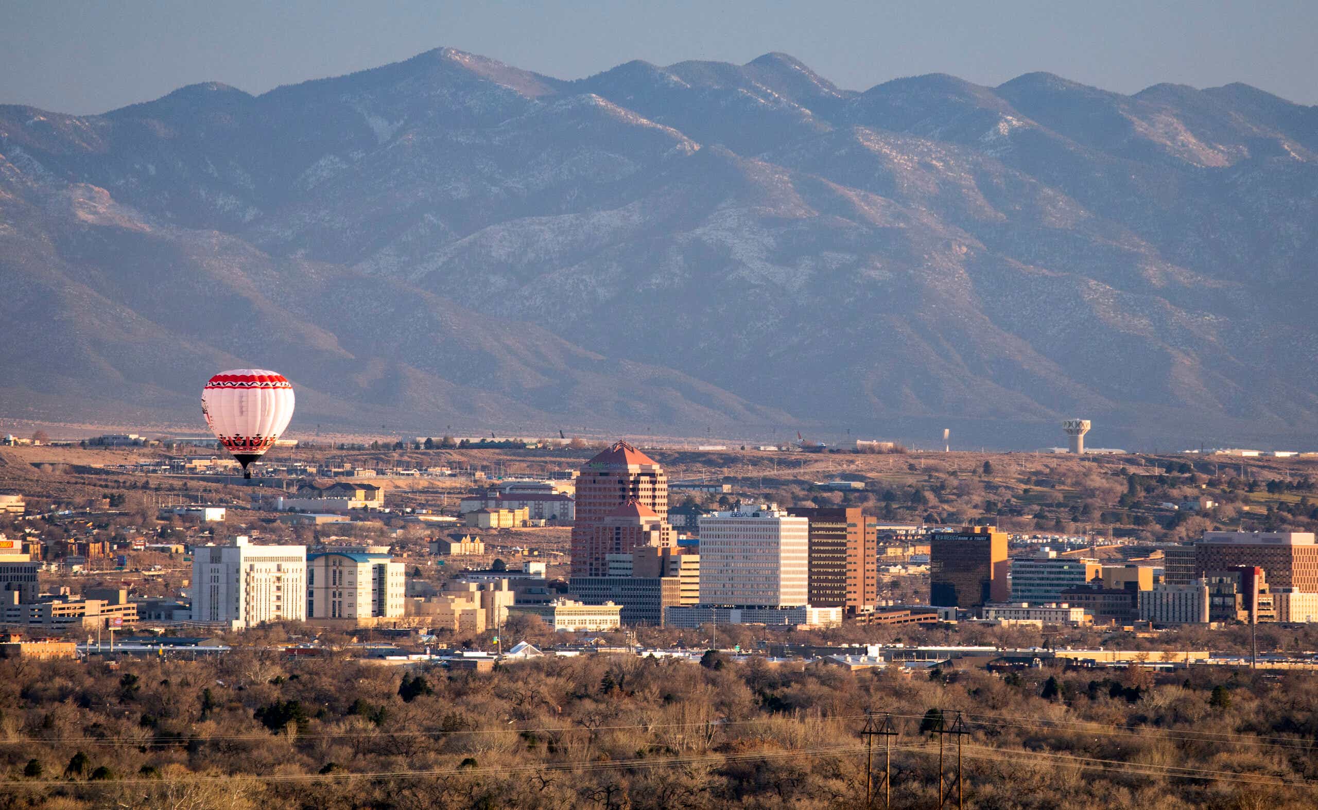 A hot air balloon floats over the skyscrapers of downtown Albuquerque, New Mexico.