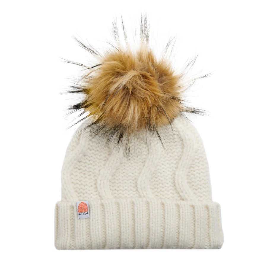 an off white beanie with a fur pompom on top