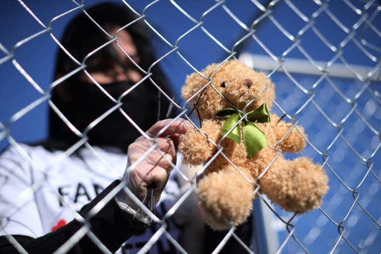 A volunteer with pro-immigration group Families Belong Together, attaches one of 600 teddy bears to a chainlink cage which 'representing the children still separated as a result of U.S. immigration policies.