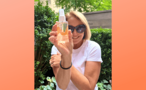 Katie Couric holding a spray bottle