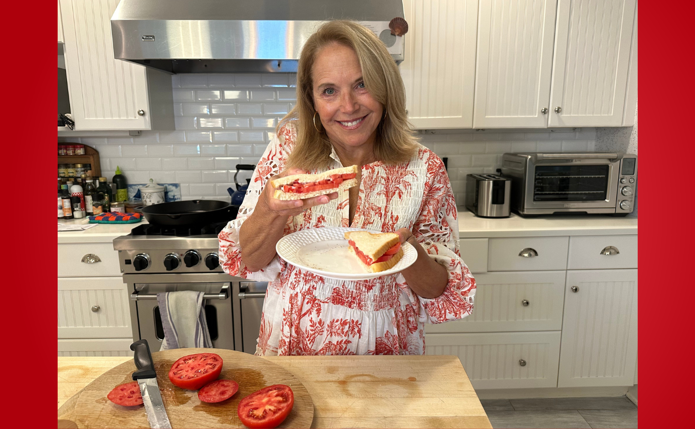 Katie Couric holding a tomato sandwich in her kitchen