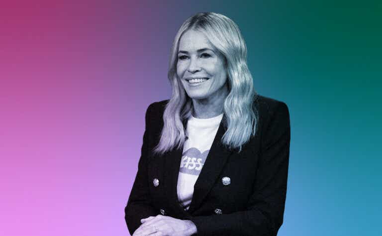 Chelsea Handler is seated with her hands folded while smiling.