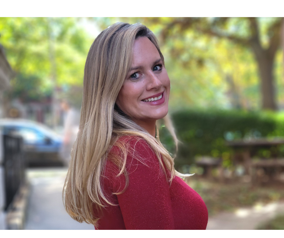 A headshot of Michelle Figueroa smiling over her shoulder on at tree-lined street.