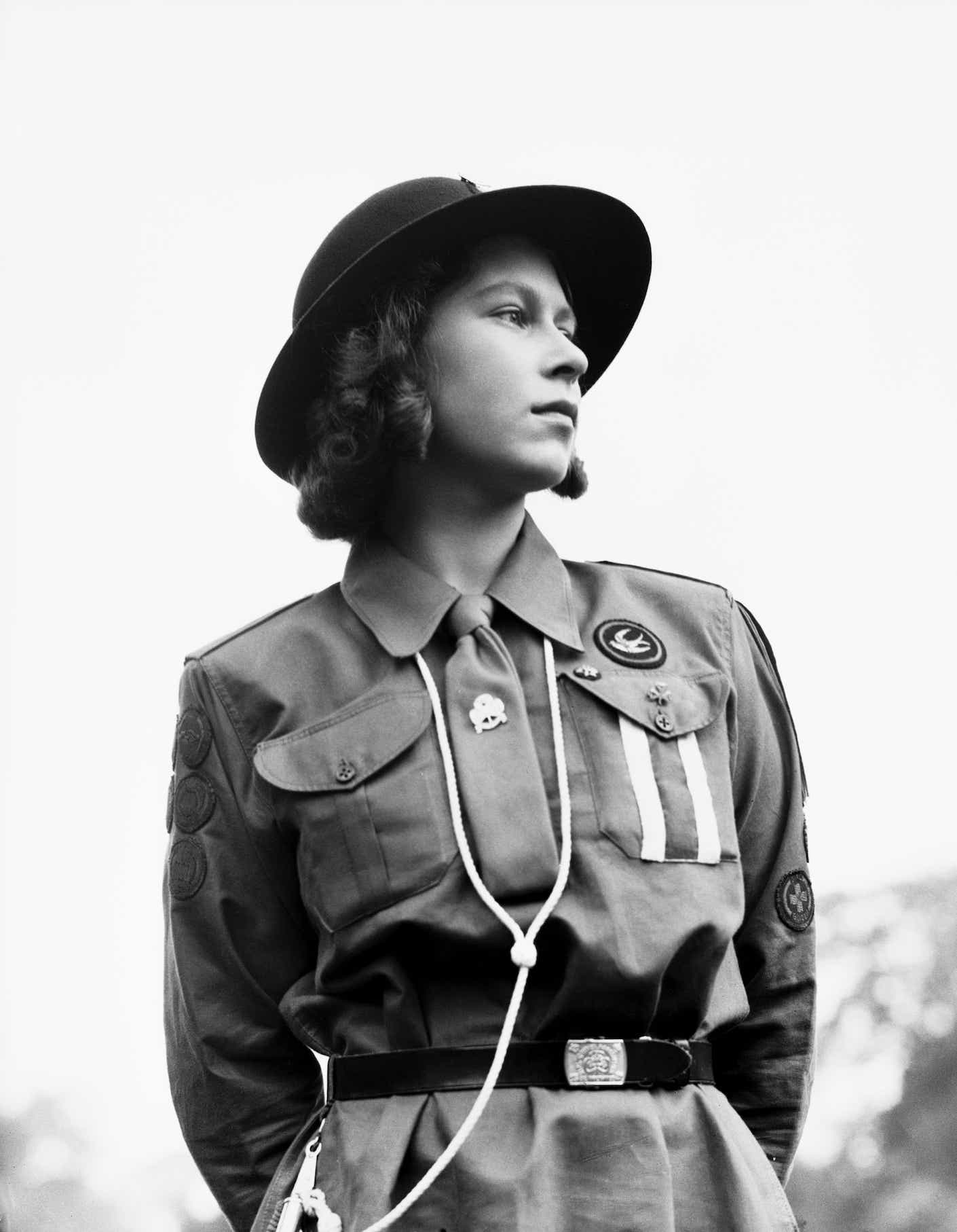 Princess Elizabeth in a Girl Guides uniform standing stoically.