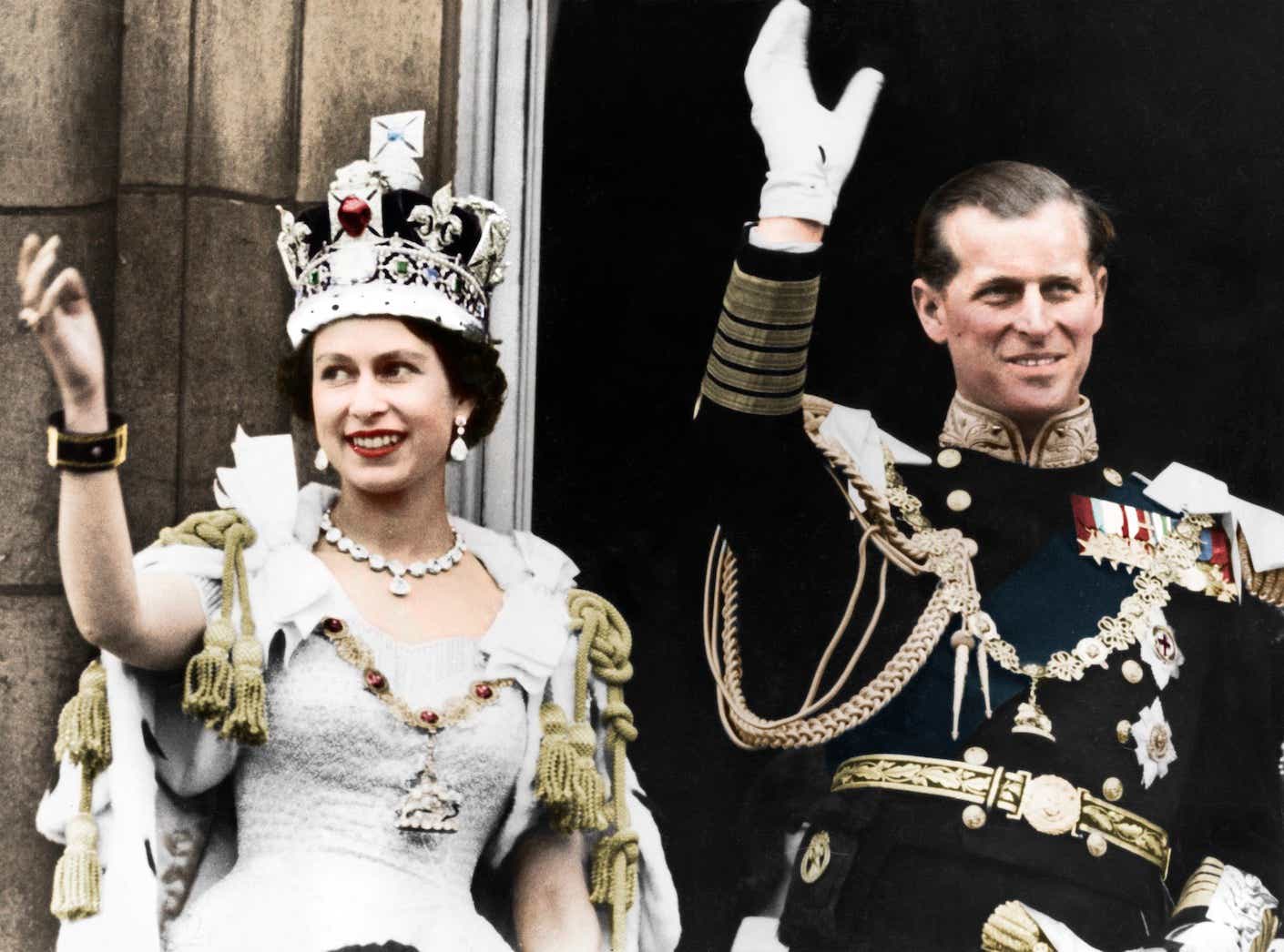 Queen Elizabeth II and the Duke of Edinburgh on the day of their coronation, Buckingham Palace, 1953. She wears an ornate robe and crown while he wears military dress.