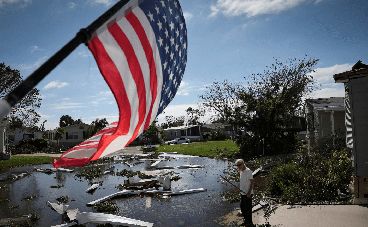 a man stands in the wake of hurricane damage in FL