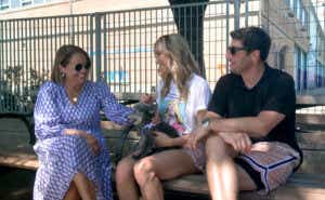Katie sits on a bench with Jenny Mollen, Jason Biggs, and their dog Gina