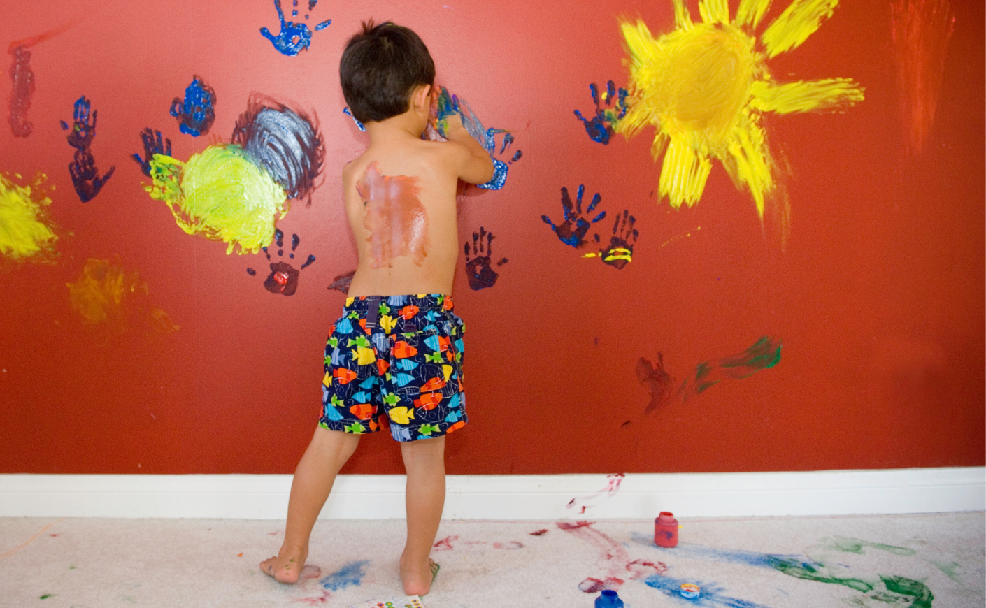 picture of boy finger painting on walls