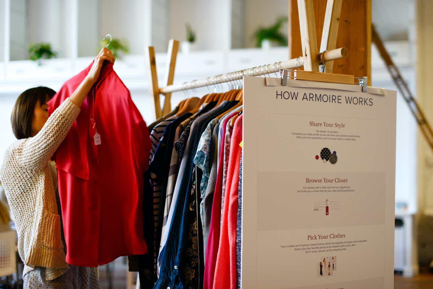 A rack of colorful clothing has an Amroire label attached.