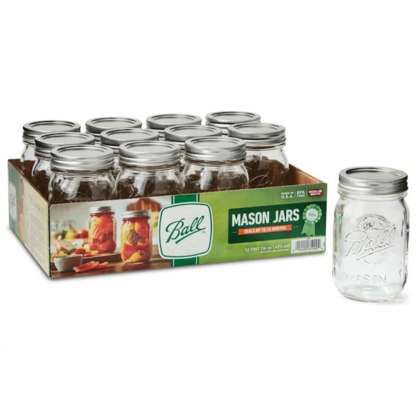 A set of 12 clear glass mason jars with metal lids sits in a flat cardboard box.