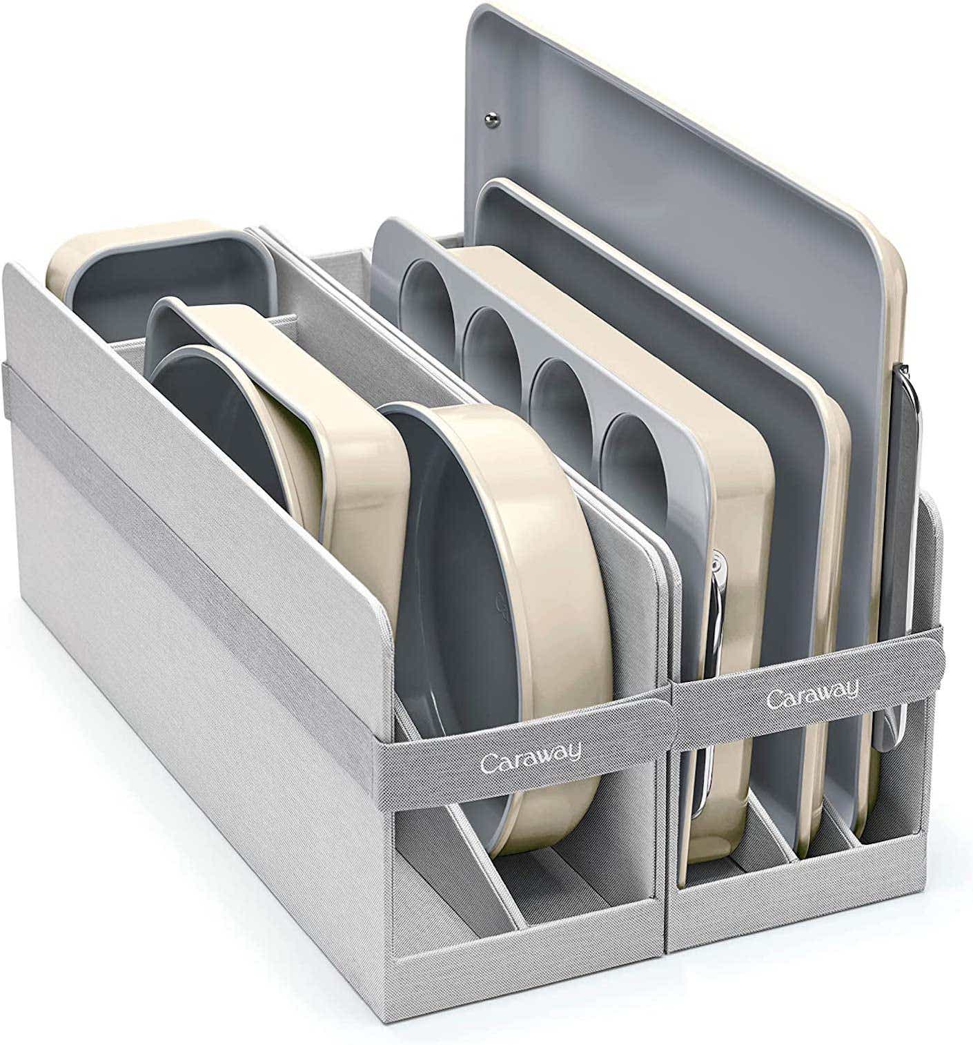 A set of metal bakeware is stacked on a metal shelf.