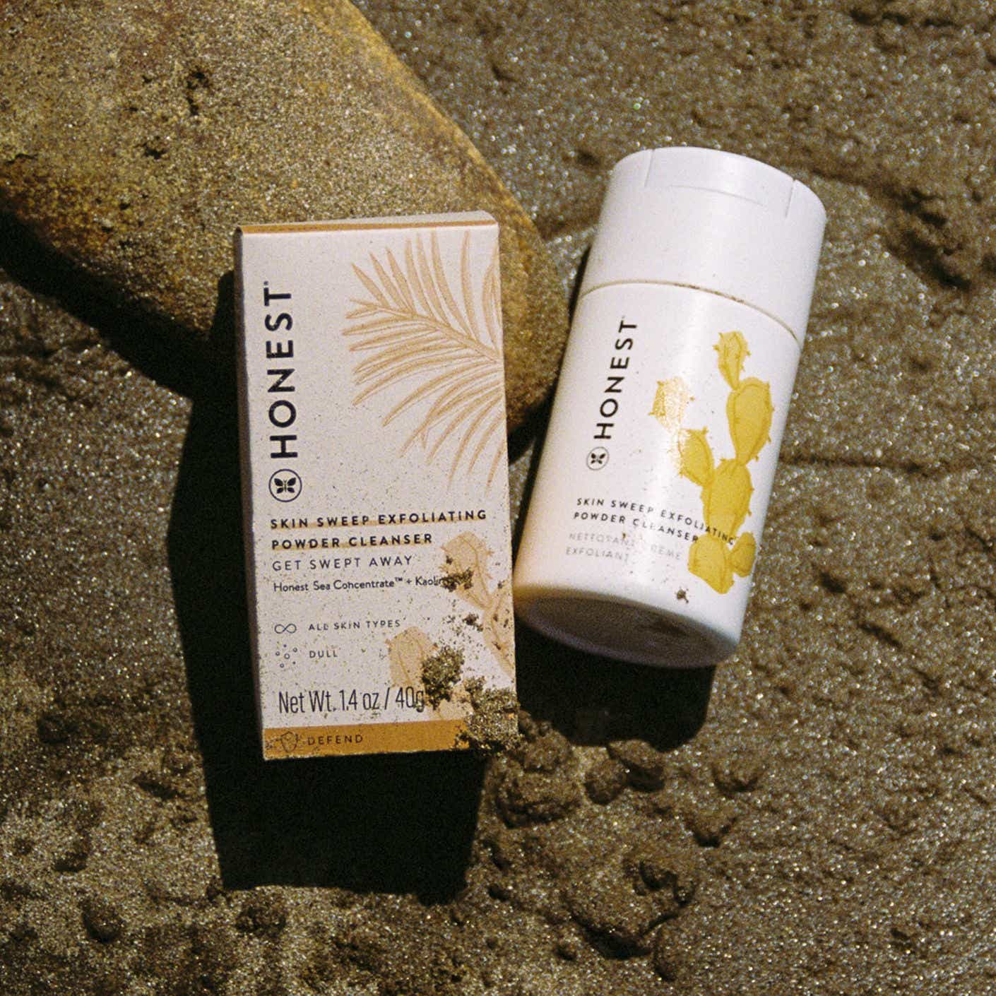 A cylindrical container of powder cleaner sits in a sunny patch of sand.