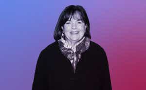 A black and white image of a smiling Ina Garten is placed in front of a purple and red ombre background.
